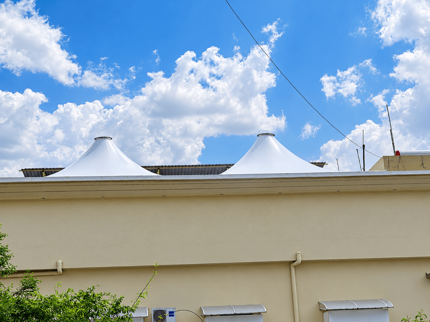 Conical tensile roof peaks visible above the Madhur Banquets building in Jalna